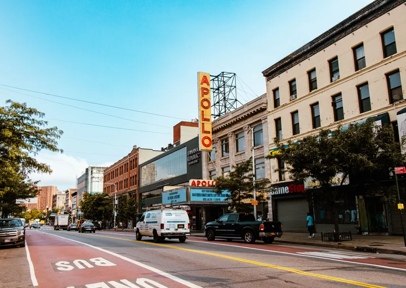 Street view of Apollo Theater in New York City, showcasing urban life and architecture.